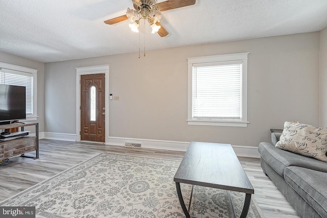 1117 Tatum St, Woodbury, NJ 08096 - living room with a textured ceiling, plenty of natural light, a ceiling fan, light wood-style floors, and baseboards