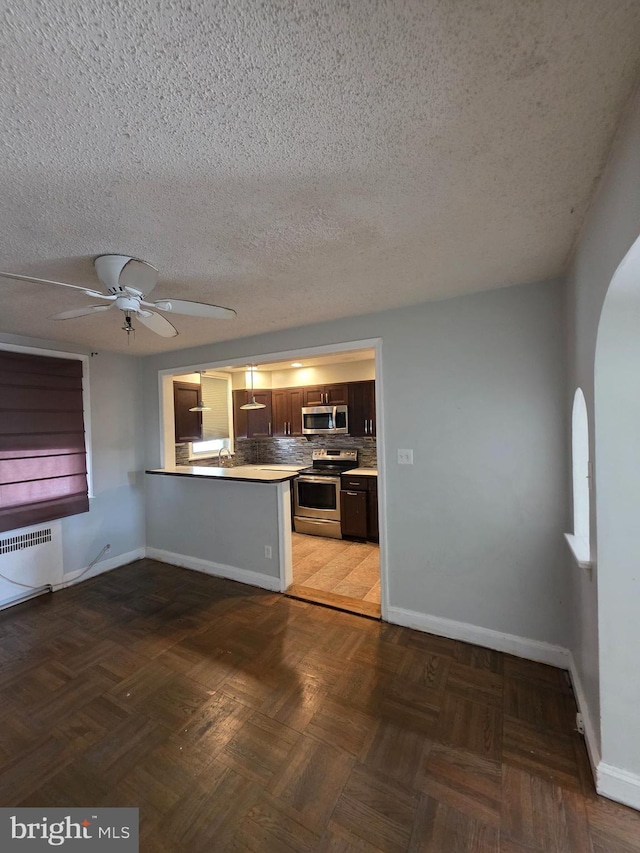 3318 Oakmont St, Philadelphia, PA 19136 - kitchen with stainless steel appliances, a peninsula, arched walkways, a ceiling fan, and a textured ceiling