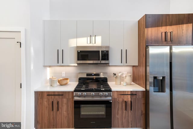 845 19th St NE Unit Ph9, Washington, DC 20002 - kitchen featuring appliances with stainless steel finishes, light countertops, backsplash, and brown cabinetry