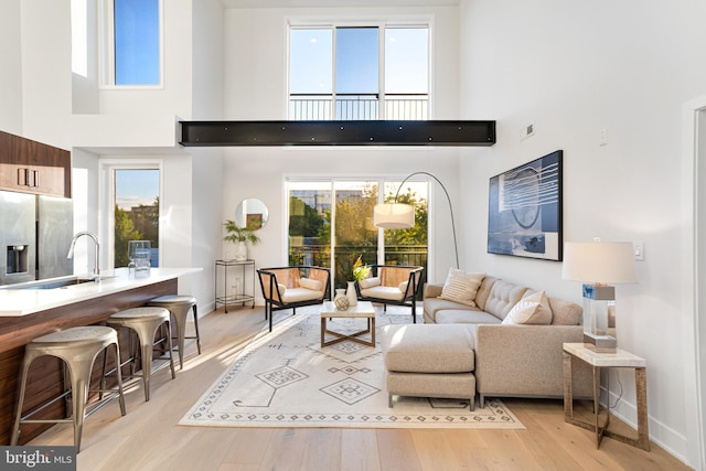 845 19th St NE Unit Ph9, Washington, DC 20002 - living room with a towering ceiling, baseboards, and light wood-type flooring