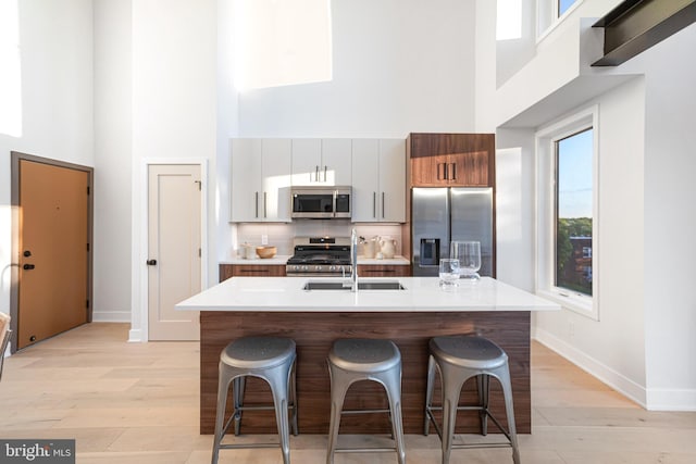 845 19th St NE Unit Ph9, Washington, DC 20002 - kitchen with appliances with stainless steel finishes, a high ceiling, a sink, light wood-type flooring, and baseboards