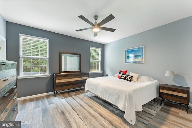 bedroom featuring wood finished floors, baseboards, and a ceiling fan