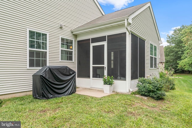rear view of house with a sunroom and a yard