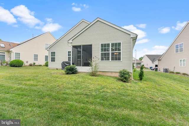back of house featuring a lawn, cooling unit, and a sunroom