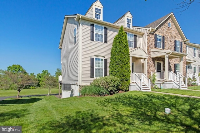 view of front facade featuring stone siding and a front lawn