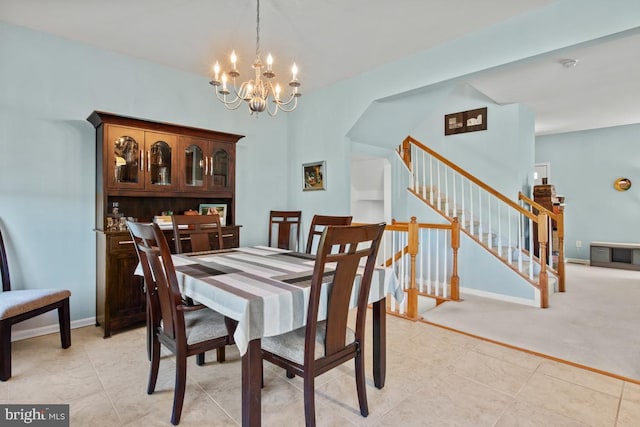 dining room featuring a chandelier, stairway, baseboards, and light tile patterned floors