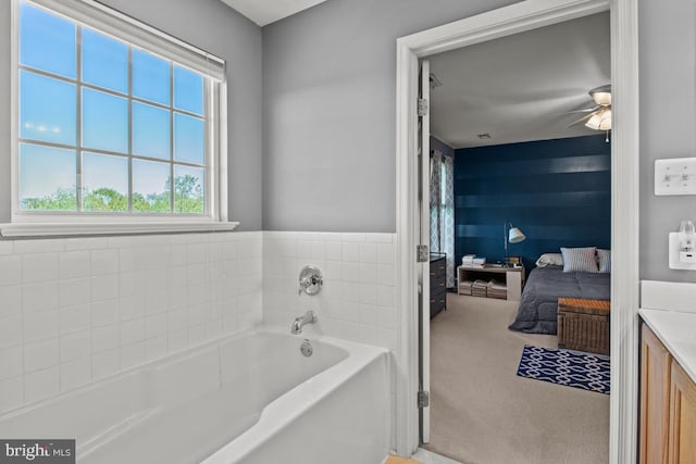 ensuite bathroom featuring a bath, ceiling fan, and vanity