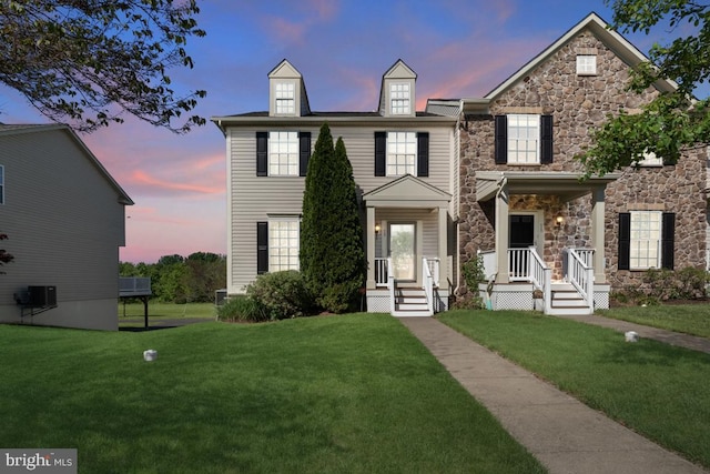 view of front facade featuring stone siding and a lawn