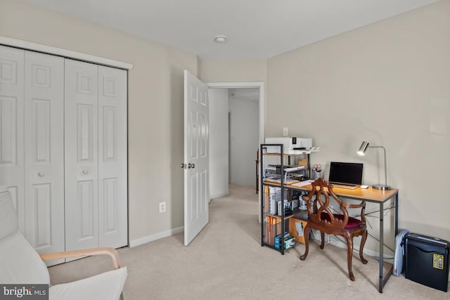 office area featuring light carpet and baseboards