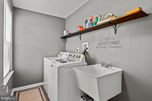 laundry room with washing machine and clothes dryer, healthy amount of natural light, and baseboards