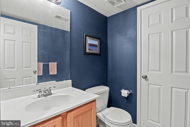 half bath featuring vanity and toilet