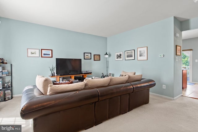 living area featuring light carpet and baseboards