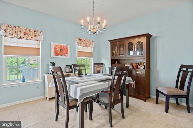 dining area featuring a chandelier, baseboards, and light tile patterned floors