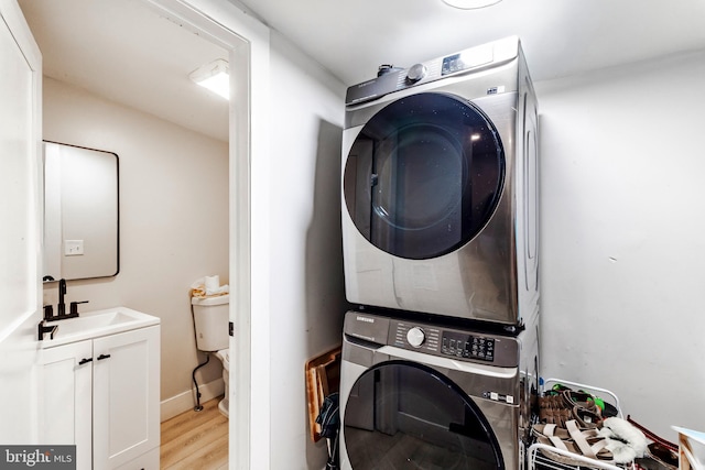 743 Cherry St, Camden, NJ 08103 - clothes washing area featuring estacked washer and dryer, light wood finished floors, and cabinet space