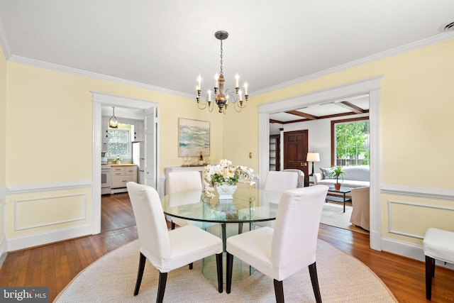 3709 Shepherd St, Chevy Chase, MD 20815 - dining space featuring wood-type flooring, a chandelier, ornamental molding, wainscoting, and a decorative wall