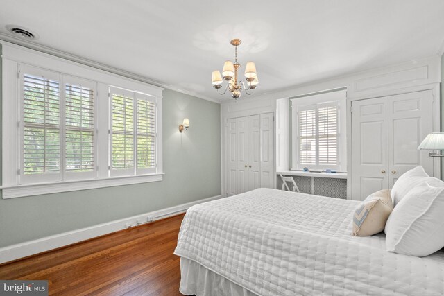 3709 Shepherd St, Chevy Chase, MD 20815 - bedroom featuring multiple closets, a chandelier, wood finished floors, baseboards, and crown molding