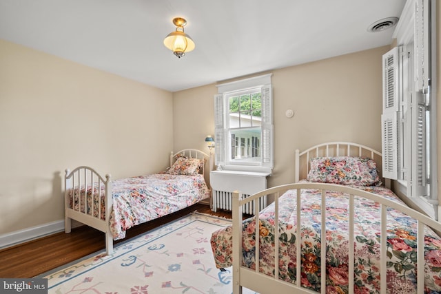 3709 Shepherd St, Chevy Chase, MD 20815 - bedroom with wood finished floors, radiator heating unit, and baseboards
