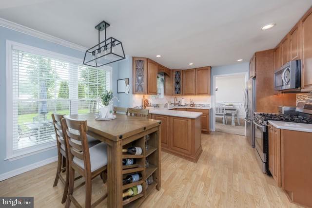 25 Aberdeen Dr, Sicklerville, NJ 08081 - kitchen featuring appliances with stainless steel finishes, healthy amount of natural light, glass insert cabinets, light countertops, and ornamental molding