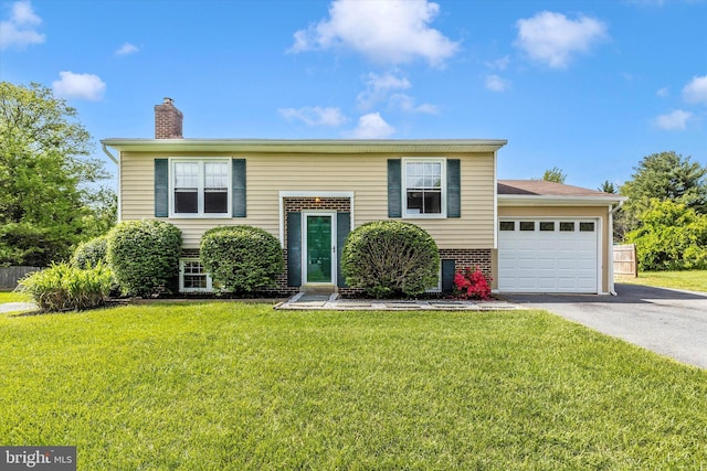 11005 Horseshoe Dr, Frederick, MD 21701 - split foyer home featuring asphalt driveway, a chimney, a garage, a front yard, and brick siding