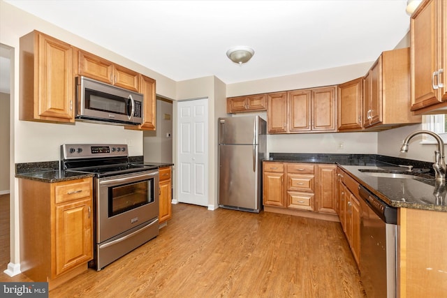 11005 Horseshoe Dr, Frederick, MD 21701 - kitchen featuring appliances with stainless steel finishes, light wood-style flooring, a sink, and dark stone counters