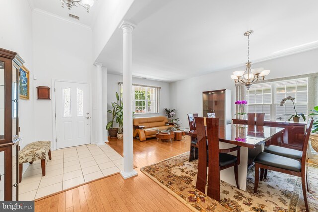 17 San Marco, West Windsor, NJ 08550 - dining area with a chandelier, ornate columns, light wood-style flooring, and ornamental molding