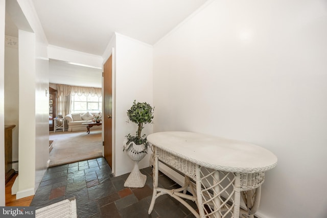 dining area featuring stone tile floors and crown molding