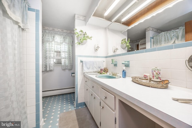bathroom with a baseboard heating unit, vanity, tile patterned floors, a shower with curtain, and tile walls