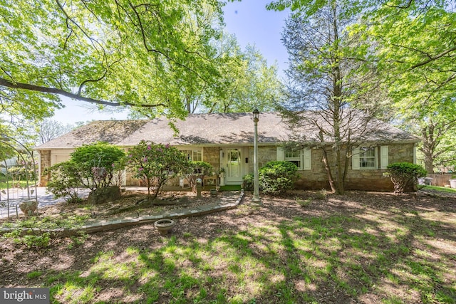 view of front of home with stone siding and a garage