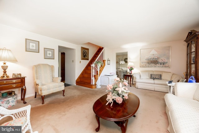 carpeted living area featuring stairway