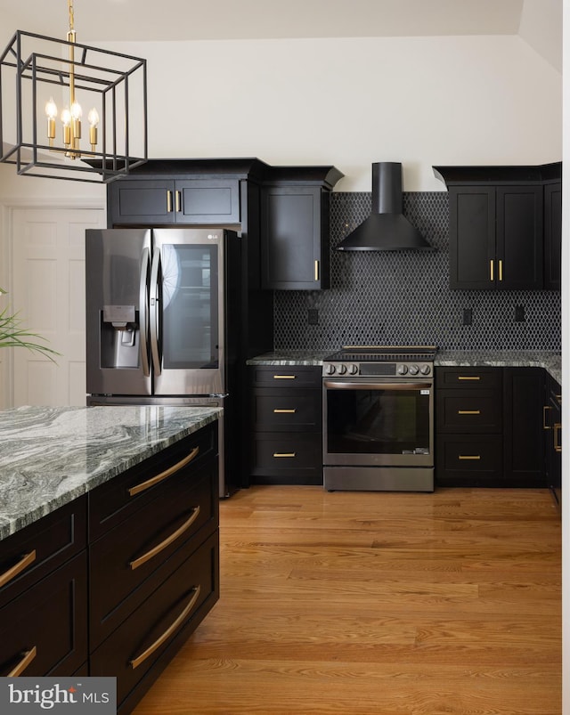 28 Stillwater Ct, Ridgeley, WV 26753 - kitchen with stainless steel appliances, wall chimney exhaust hood, light stone counters, a chandelier, and dark cabinetry