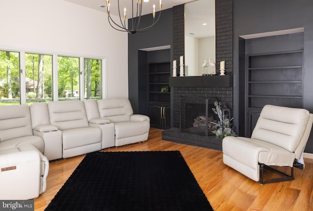 28 Stillwater Ct, Ridgeley, WV 26753 - living room with a chandelier, wood finished floors, a towering ceiling, a brick fireplace, and built in features
