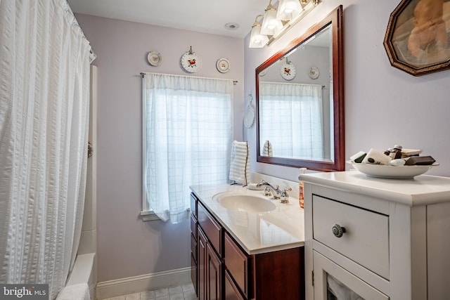full bathroom featuring vanity, baseboards, and shower / tub combo