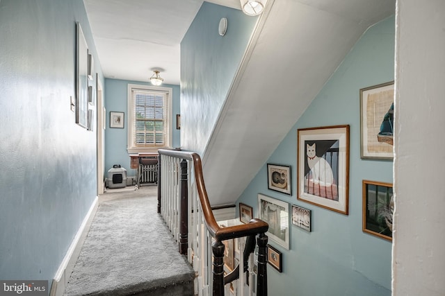 stairway featuring carpet floors, baseboards, and lofted ceiling