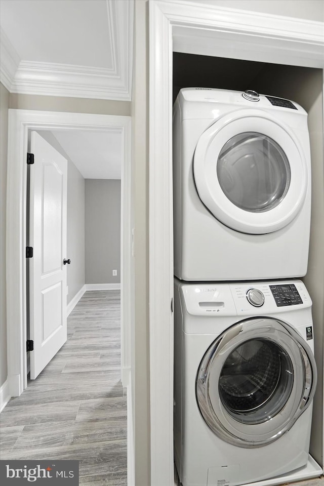 6624 Aaron Mee Way, Baltimore, MD 21237 - clothes washing area featuring stacked washer / dryer, baseboards, light wood finished floors, and ornamental molding