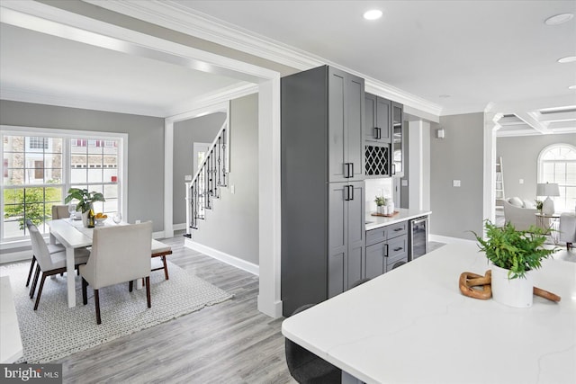 6624 Aaron Mee Way, Baltimore, MD 21237 - dining area with beverage cooler, crown molding, baseboards, stairway, and light wood-style flooring