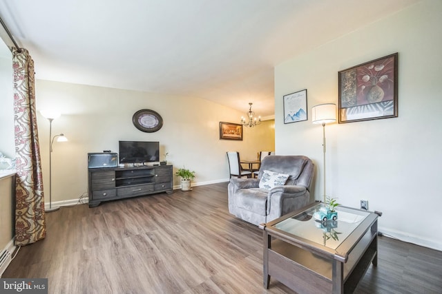 living room with wood finished floors, a chandelier, baseboards, and lofted ceiling