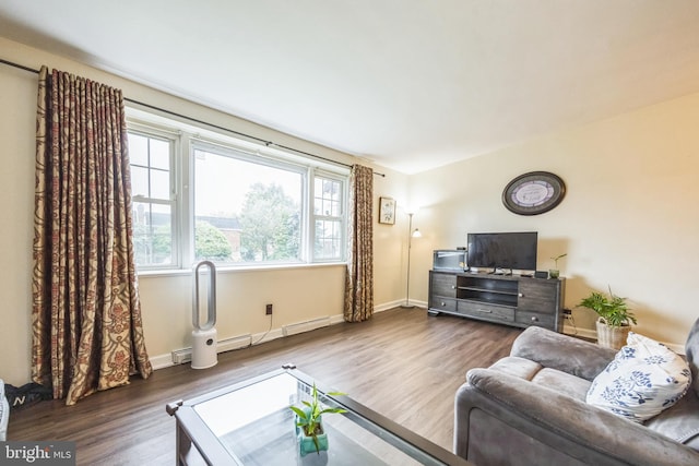 living area with wood finished floors, a baseboard radiator, and baseboards