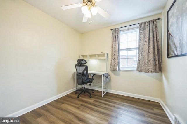 unfurnished office featuring wood finished floors, baseboards, and ceiling fan