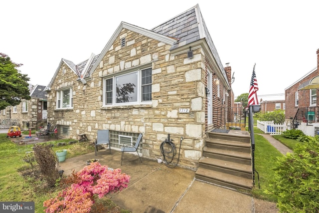 view of home's exterior with stone siding and a patio