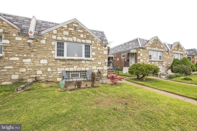 view of home's exterior featuring a yard, a high end roof, and stone siding
