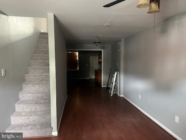 hallway featuring wood finished floors, stairs, and baseboards