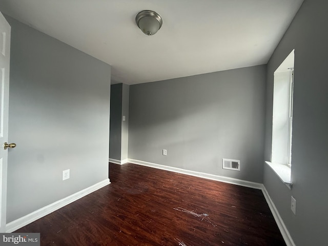 spare room featuring wood finished floors and baseboards