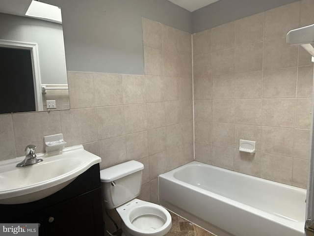 bathroom with tile walls, vanity, and toilet