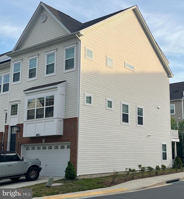view of side of property with a garage and brick siding