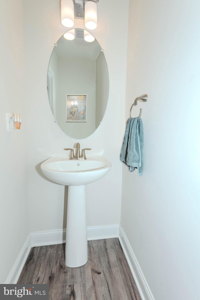 bathroom with wood finished floors and baseboards