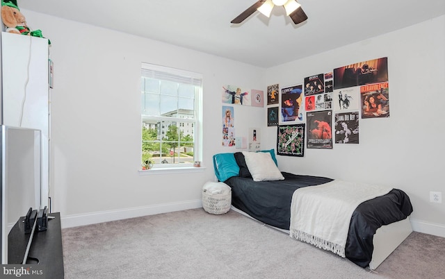 carpeted bedroom with baseboards and ceiling fan