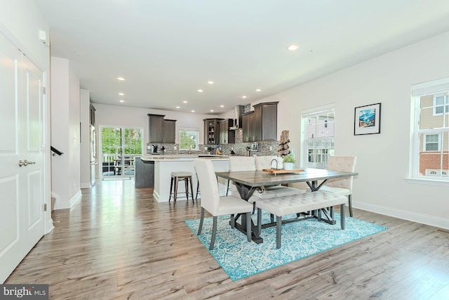 dining area with light wood-type flooring, baseboards, and recessed lighting