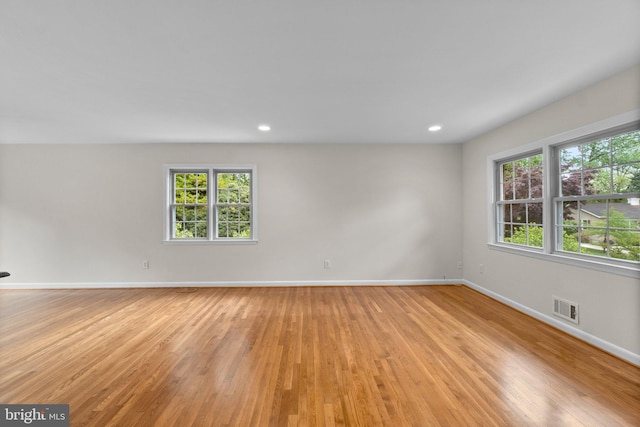 empty room featuring light wood-style floors, healthy amount of natural light, baseboards, and recessed lighting