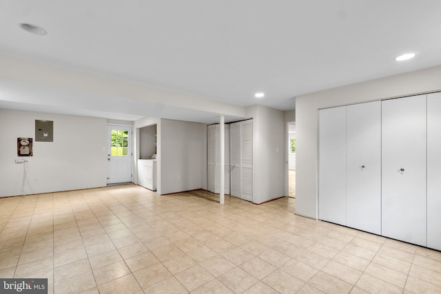 unfurnished bedroom with washer / dryer, electric panel, recessed lighting, and multiple closets
