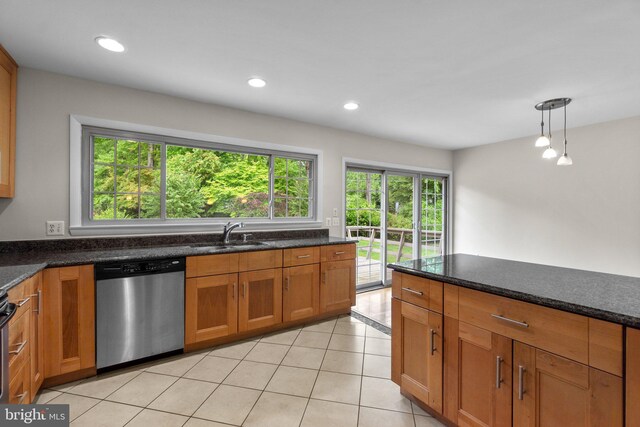 kitchen featuring stainless steel dishwasher, a sink, brown cabinetry, recessed lighting, and dark stone counters